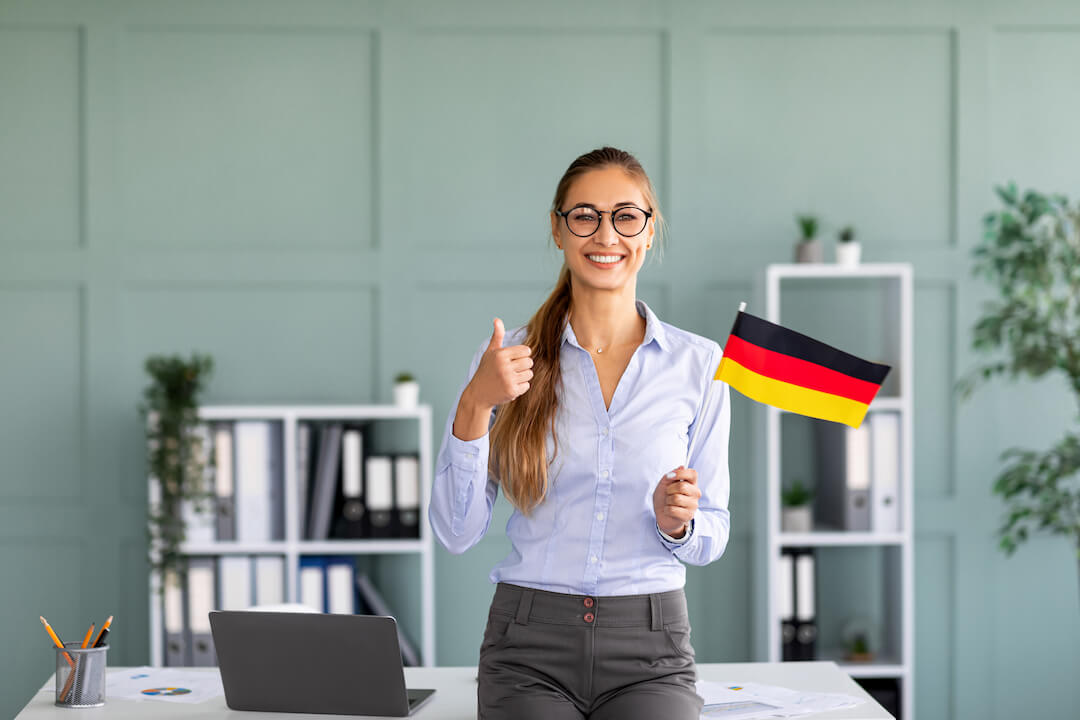 happy-female-tutor-with-flag-of-germany-showing-th-2021-12-09-04-47-28-utc copy