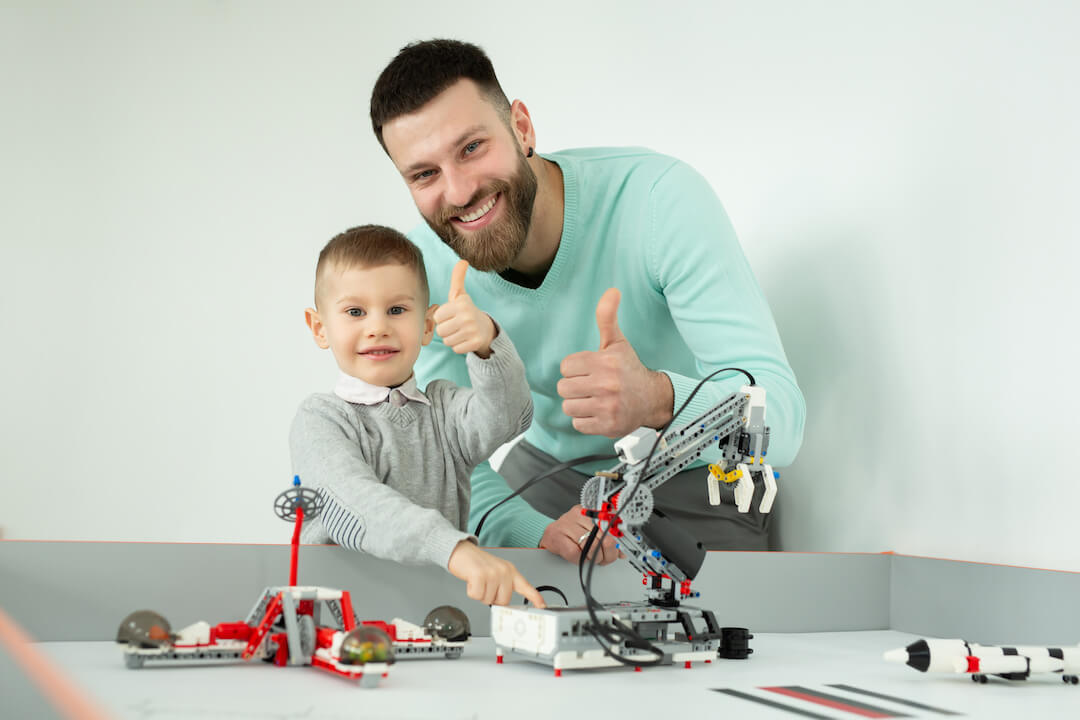 dad-plays-with-his-son-in-robot-cars-at-a-robotics-2023-01-06-23-00-57-utc-2