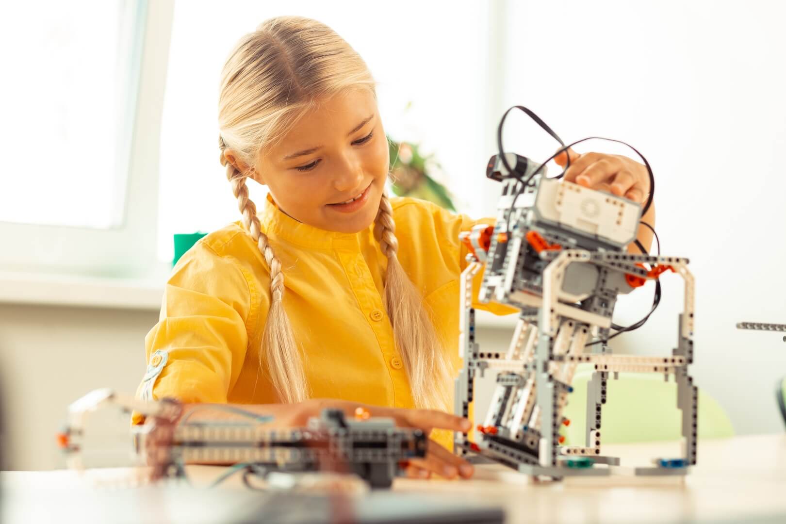 girl-playing-with-a-robot-at-science-lesson-2022-01-27-21-36-25-utc-2